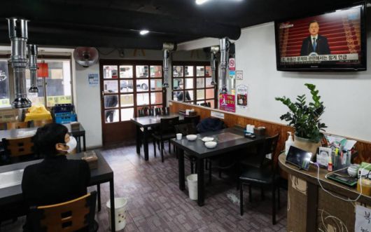 [서울=뉴시스] 권창회 기자 = 3일 오전 서울 시내 한 식당에서 식당점주가 문재인 대통령 신년사를 시청하고 있다. 2022.01.03.