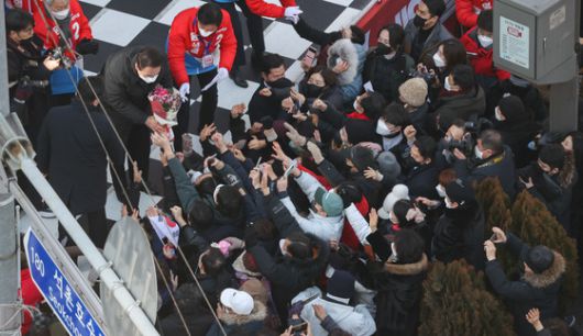 (서울=뉴스1) 국회사진취재단 = 윤석열 국민의힘 대선 후보가 17일 오후 서울 송파구 석촌호수에서 열린 "경제를 살리는 대통령!" 송파 유세에서 지지자로부터 꽃다발을 받고 있다. 2022.2.17/뉴스1