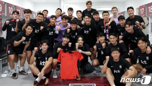 그룹 방탄소년단(BTS) 정국이 지난 19일(현지시간) 카타르 월드컵 대한민국 축구 국가대표팀 훈련장을 방문해 선수들과 기념촬영을 하고 있다. /사진=뉴스1, 대한축구협회 제공