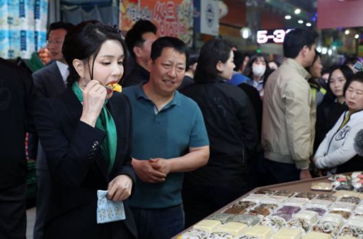 윤석열 대통령 부인 김건희 여사가 14일 오후 대전 중구 태평전통시장을 방문해 떡을 맛보고 있다. /사진=뉴시스