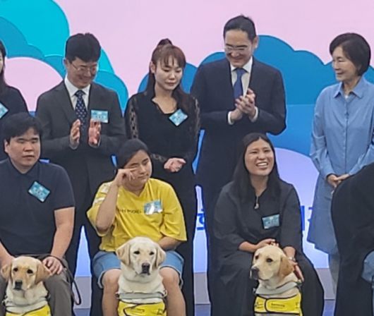 19일 경기도 용인시 삼성화재 안내견학교 기념식에서 안내견을 바라보며 흐뭇해하는 이재용 삼성전자 회장(가장 윗줄 오른쪽 2번째)과 홍라희 전 리움미술관 관장(가장 윗줄 오른쪽 1번째). / 사진 = 오진영 기자