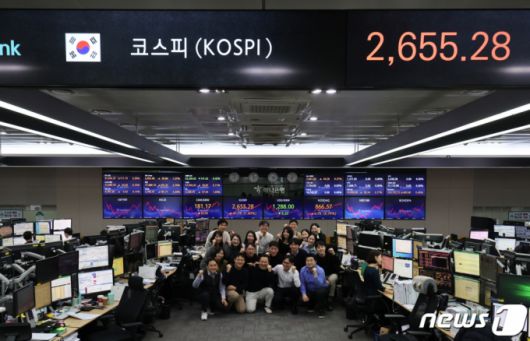 (서울=뉴스1) 김도우 기자 = 28일 오후 서울 중구 하나은행 딜링룸에서 직원들이 올해 마지막 거래일을 기념해 사진을 촬영하고 있다.  이날 코스피 지수는 전 거래일 대비 41.78포인트(1.60%) 오른 2655.28으로, 코스닥 지수는 6.78포인트(0.79%) 상승한 866.57으로 마감했다. 원·달러 환율은 전 거래일 대비 6.2원 내린 1288.0원으로 거래를 마감했다. 2023.12.28/뉴스1  Copyright (C) 뉴스1. All rights reserved. 무단 전재 및 재배포,  AI학습 이용 금지.