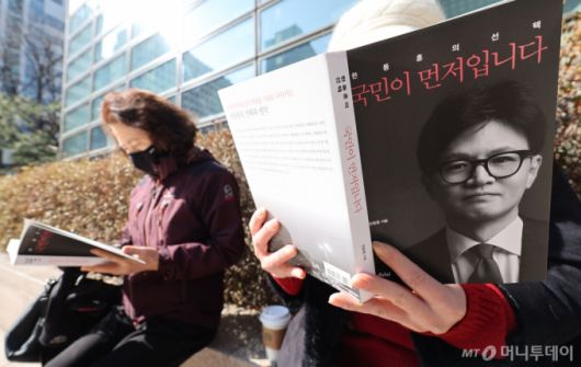 26일 서울의 한 대형 서점에서 시민들이 이날 출간한 국민의힘 한동훈 전 대표의 저서 '국민이 먼저다'를 구매후 책을 읽고 있다.  2025.2.26/사진=뉴스1
