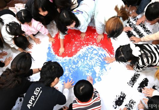 [수원=뉴시스] 김종택 기자 = 제106주년 삼일절을 이틀 앞둔 27일 경기도 수원시 세류1동 새마을문고 책먹는 아이들에서 열린 '나라사랑 한마음 손도장 태극기 만들기' 행사에서 어린이들이 물감으로 손도장 태극기를 그리고 있다. 2025.02.27. jtk@newsis.com /사진=김종택