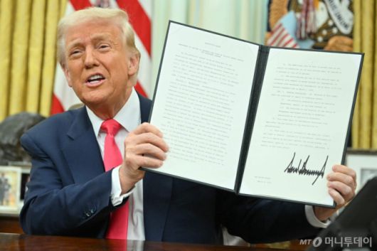 (워싱턴 AFP=뉴스1) 우동명 기자 = 도널드 트럼프 미국 대통령이 6일(현지시간) 워싱턴 백악관에서 멕시코와 캐나다에서 수입되는 제품 중 USMCA에 적용되는 품목에 대해서는 내달 2일까지 '25% 관세'를 면제하는 행정명령에 서명을 한 뒤 들어 보이고 있다. 2025.03.07  ⓒ AFP=뉴스1  Copyright (C) 뉴스1. All rights reserved. 무단 전재 및 재배포,  AI학습 이용 금지. /사진=(워싱턴 AFP=뉴스1) 우동명 기자