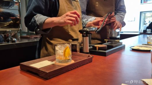 스타벅스 리저브 도산의 바리스타가 매장의 전용 메뉴 ‘리저브 스모크드 콜드 패션드’를 만들고 있는 모습./사진=유예림 기자