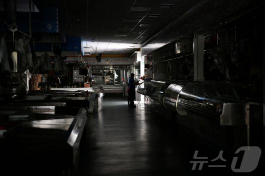 28일(현지시간) 대규모 정전이 발생한 동안 스페인 북서부 비고에서 지역 시장을 한 남성과 어린이가 걸어가고 있다. 2025.04.28.ⓒ AFP=뉴스1