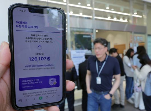 해킹 공격으로 가입자 유심 정보가 탈취된 SK텔레콤이 가입자 유심 무상 교체를 시작한 28일 오전 서울 종로구 T월드 매장 앞에서 직원들의 안내를 받아 온라인 예약을 하고 있다. /사진=뉴스1