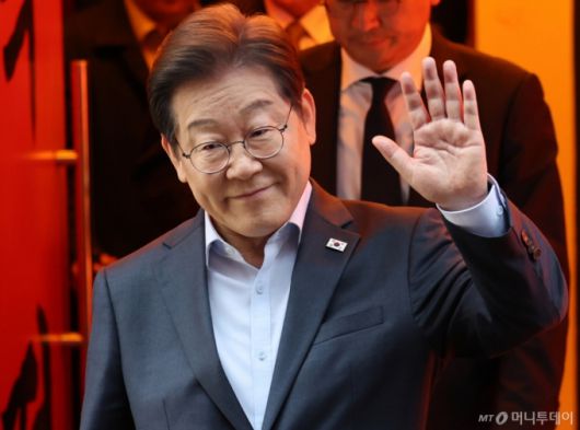 (서울=뉴스1) 이재명 기자 = 이재명 더불어민주당 대통령 후보가 1일 서울 종로구의 한 포차 식당에서 '당신의 하루를 만드는, 보이지 않는 영웅들'이란 주제로 열린 배달 라이더, 택배 기사 등 비(非)전형 노동자들과 간담회를 마친 뒤 나서며 손인사를 하고 있다. (공동취재) 2025.5.1/뉴스1  Copyright (C) 뉴스1. All rights reserved. 무단 전재 및 재배포,  AI학습 이용 금지. /사진=(서울=뉴스1) 이재명 기자