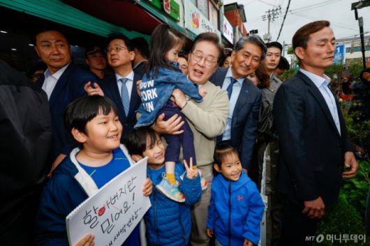 (옥천=뉴스1) 안은나 기자 = 이재명 더불어민주당 대통령 후보가 골목골목 경청투어 이틀차인 6일 오후 충북 옥천군 공설시장을 찾아 아이를 안고 있다. 2025.5.6/뉴스1  Copyright (C) 뉴스1. All rights reserved. 무단 전재 및 재배포,  AI학습 이용 금지. /사진=(옥천=뉴스1) 안은나 기자
