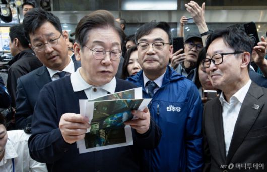 (단양=뉴스1) 이재명 기자 = '골목골목 경청투어 : 단양팔경편'에 나선 이재명 더불어민주당 대통령 후보가 4일 오전 충북 단양군 단양구경시장에서 상인이 건네 준 편지를 읽어보고 있다. 2025.5.4/뉴스1  Copyright (C) 뉴스1. All rights reserved. 무단 전재 및 재배포,  AI학습 이용 금지. /사진=(단양=뉴스1) 이재명 기자