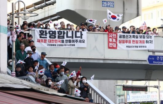 제21대 대통령 선거 공식 선거운동 첫날인 12일 김문수 국민의힘 대통령 후보가 대구 중구 서문시장에서 유세를 하고 있는 가운데 시민들이 태극기를 들고 응원하고 있다. 2025.5.12/사진=뉴스1 /사진=(대구=뉴스1) 김민지 기자