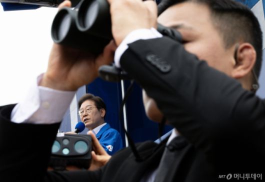 [군산=뉴시스] 조성우 기자 = 이재명 더불어민주당 대선후보가 16일 전북 군산시 구시청광장에서 열린 유세에서 연설하는 가운데 경호원들이 망원경으로 주변을 감시하고 있다. (공동취재) 2025.05.16. photo@newsis.com /사진=