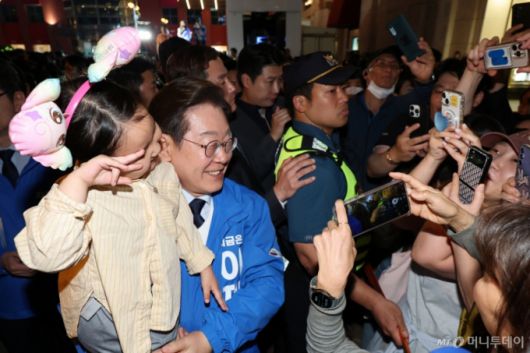 (울산=뉴스1) 안은나 기자 = 이재명 더불어민주당 대통령 후보가 대표적 험지인 대구·경북(TK) 지역 유세에 돌입한 13일 오후 울산 남구 롯데백화점 광장에서 유세 후 어린이와 기념촬영을 하고 있다.2025.5.13/뉴스1 2025.5.13/뉴스1  Copyright (C) 뉴스1. All rights reserved. 무단 전재 및 재배포,  AI학습 이용 금지. /사진=(울산=뉴스1) 안은나 기자