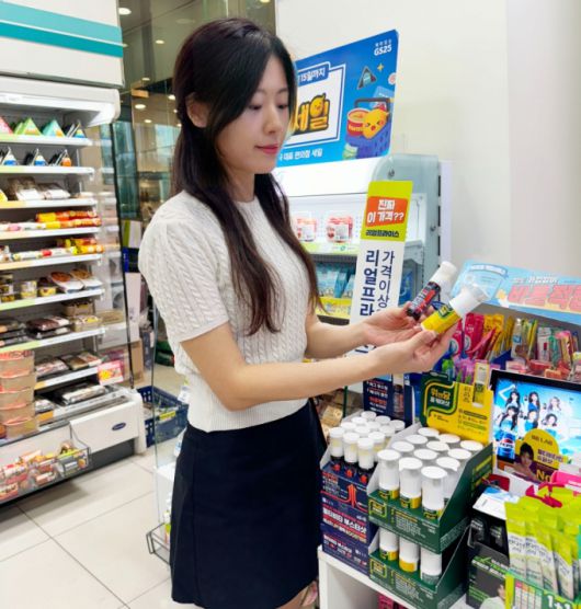 GS25 매장 내 건강식품 매대에서 모델이 비타민 이중제형 제품을 고르고 있다. /사진제공=GS리테일