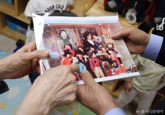 [광명=뉴시스] 고승민 기자 = 김문수 국민의힘 대선 후보와 설난영 여사가 22일 경기 광명시의 한 어린이집에서 아이들을 만나던 중 딸 동주 씨의 어린시절 사진을 보고 있다. 2025.05.22. kkssmm99@newsis.com /사진=고승민