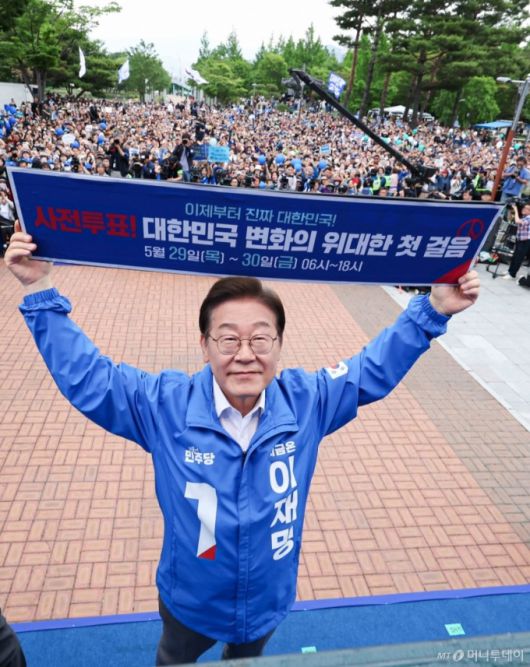 (양산=뉴스1) 이재명 기자 = 이재명 더불어민주당 대통령 후보가 22일 오후 경남 양산시 양산워터파크공원에서 열린 유세에서 '사전투표! 대한민국 변화의 위대한 첫 걸음'이라고 적힌 현수막을 들어보이고 있다. (공동취재) 2025.5.22/뉴스1  Copyright (C) 뉴스1. All rights reserved. 무단 전재 및 재배포,  AI학습 이용 금지. /사진=(양산=뉴스1) 이재명 기자