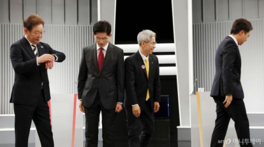 [서울=뉴시스] 국회사진기자단 = 23일 서울 영등포구 KBS본관 스튜디오에서 열린 중앙선거방송토론위원회 주관 제21대 대통령선거 2차 후보자 토론회 시작에 앞서 각 정당 대선후보들이 기념촬영을 마친 뒤 자리로 돌아가고 있다. 왼쪽부터 이재명 더불어민주당, 김문수 국민의힘, 권영국 민주노동당, 이준석 개혁신당 대선후보. 2025.05.23. photo@newsis.com /사진=