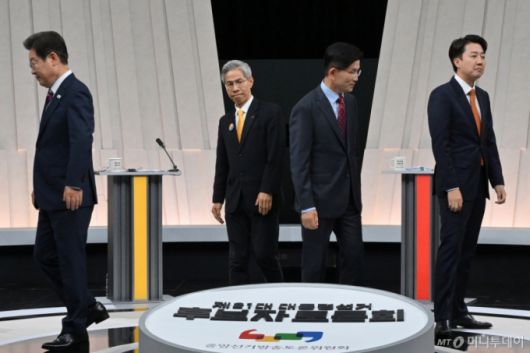 [서울=뉴시스] 국회사진기자단 = 27일 오후 서울 마포구 상암동 MBC 스튜디오에서 열린 중앙선거방송토론위원회 주관 제21대 대통령선거 3차 후보자토론회 시작에 앞서 각 정당 대선후보들이 기념촬영을 마친 뒤 자리로 돌아가고 있다. 왼쪽부터 이재명 더불어민주당, 권영국 민주노동당, 김문수 국민의힘, 이준석 개혁신당 대선후보. 2025.05.27. photo@newsis.com /사진=