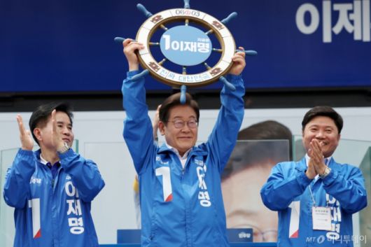 [평택=뉴시스]  이재명 더불어민주당 대선후보가 31일 오후 경기 평택시 배다리생태공원에서 열린 유세에서 '진짜 대한민국' 이라고 적힌 조타기를 들어 보이고 있다. 2025.05.31.