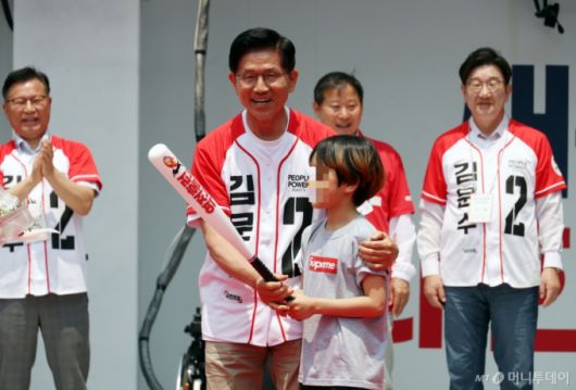 [속초=뉴시스] 김문수 국민의힘 대선 후보가 31일 강원 속초 관광수산시장에서 유세를 하기 전 선물받은 야구 배트를 들고 포즈를 취하고 있다. 2025.05.31.