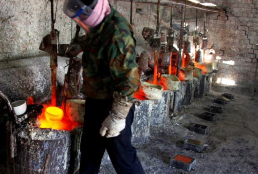 중국 내몽골 자치구 다마오 마을 인근의 희토류 제련 공장에서 한 작업자가 희토류 금속 란타늄을 주형에 부을 준비를 하고 있다. /로이터=뉴스1