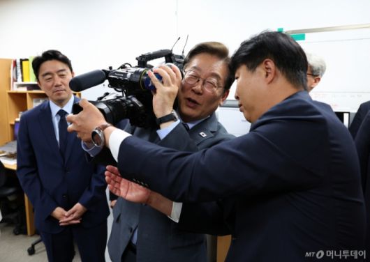 [서울=뉴시스] 최진석 기자 = 이재명 대통령이 12일 서울 용산 대통령실 영상기자실을 방문해 영상카메라를 들어 보이고 있다. 2025.06.12. myjs@newsis.com /사진=최진석