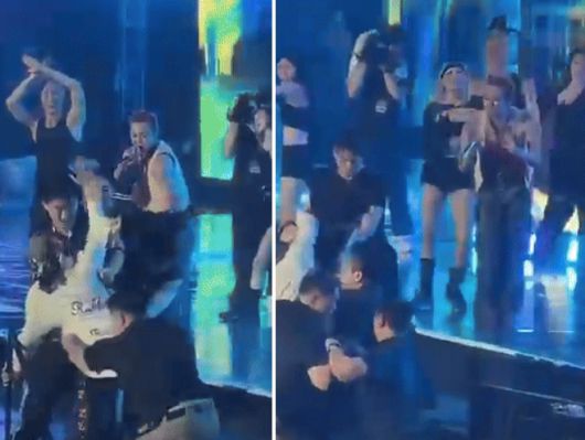 지난 21일(현지시간)  베트남 하노이의 미딘 국립경기장에서 열린 'K-STAR SPARK IN VIETNAM 2025'에서 무대를 펼치던 가수 지드래곤이 난입한 관객을 바라보며 미소짓고 있다. /사진=엑스 갈무리