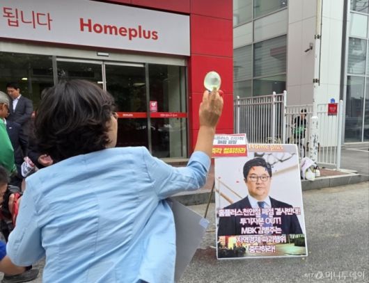 마트 노동자들이 2일 천안시 동남구 홈플러스 천안점 앞에서 열린 폐점 반대 기자회견에서 김병주 MBK파트너스 회장을 규탄하며 얼굴 사진에 물풍선을 던지고 있다. 2025.6.2/뉴스1  Copyright (C) 뉴스1. All rights reserved. 무단 전재 및 재배포,  AI학습 이용 금지. /사진=(천안=뉴스1) 이시우 기자