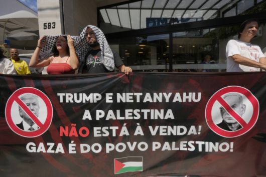 지난 2월 13일(현지 시간) 브라질 상파울루의 미국 총영사관 밖에서 친팔레스타인 시위대가 도널드 트럼프 미국 대통령의 팔레스타인인을 가자지구 밖으로 영구히 이주시키자는 제안과 해당 지역을 ‘중동의 리비에라’로 재개발하겠다는 구상에 반대하며 펼침막을 들고 있다. 이들이 들고 있는 펼침막에는 "트럼프와 네타냐후! 팔레스타인은 판매 대상이 아냐. 가자는 팔레스타인인의 것"이라고 쓰여 있다./AP=뉴시스