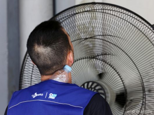 (서울=뉴스1) 황기선 기자 = 연일 폭염이 이어지고 있는 9일 서울 시내 한 택배물류센터에서 노동자가 택배 분류 작업 중 더위를 식히고 있다.  2025.7.9/뉴스1  Copyright (C) 뉴스1. All rights reserved. 무단 전재 및 재배포,  AI학습 이용 금지. /사진=(서울=뉴스1) 황기선 기자