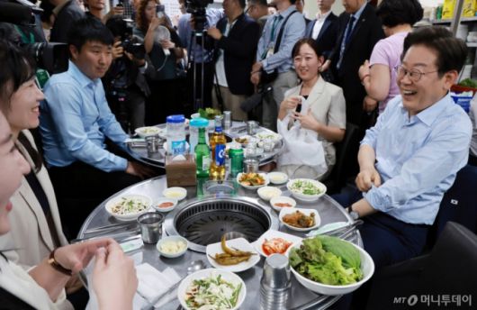 [서울=뉴시스] 최동준 기자 = 이재명 대통령이 11일 서울 종로구 한 식당에서 시민들과 '삼겹살 외식'을 하고 있다.  이 대통령은 SNS에 식사 계획을 알리며 "이처럼 어려운 시기에 21일부터 시행되는 민생회복 소비쿠폰 정책이 내수 진작과 지역 경제 활성화에 활력을 불어넣길 기대한다"고 밝혔다. (대통령실통신사진기자단) 2025.07.11. photocdj@newsis.com /사진=최동준