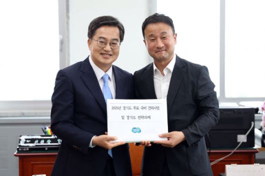 김동연 경기도지사(왼쪽)가 한병도 국회 예산결산위원장에게 '2025년 경기도 주요 국비 건의사업 및 경기도 전략과제' 를 전달한 뒤 기념촬영을 하고 있다. /사진제공=경기도
