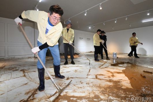 [광주=뉴시스] 이영주 기자 = 박찬대 더불어민주당 당대표 후보가 21일 오후 광주 서구 한 수해 피해 가구백화점을 찾아 수해복구 봉사활동에 참여하며 밀대를 이용해 흙탕물을 정리하고 있다. 광주에는 지난 17일 하루에만 426.4㎜의 비가 내렸다. 1939년 기상관측 이후 역대 최고 일 강수량으로 종전 기록인 1989년 7월25일 335.6㎜와 비교해 90.8㎜나 많았다. 2025.07.21. leeyyj2578@newsis.com /사진=