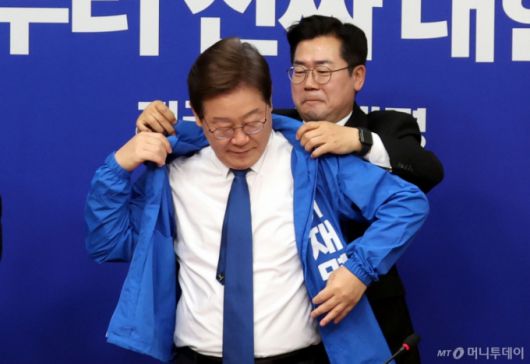 [서울=뉴시스] 조성봉 기자 = 박찬대 더불어민주당 대표 직무대행 겸 원내대표가 28일 오전 서울 여의도 국회에서 열린 최고위원회의에서 이재명 더불어민주당 제21대 대통령 선거 후보의 선거운동복을 입혀주고 있다. 2025.04.28. suncho21@newsis.com /사진=조성봉