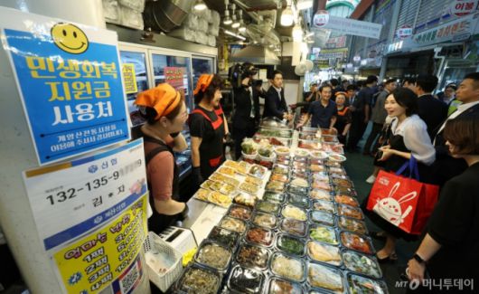 [인천=뉴시스] 고범준 기자 = 이재명 대통령 부인 김혜경 여사가 25일 인천 계양산전통시장을 찾아 민생회복 소비쿠폰을 이용해 음식을 구매한 뒤 상인과 인사하고 있다. 2025.07.25. bjko@newsis.com /사진=고범준