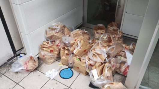 일본 한 건물 입구에 버려진 햄버거가 가득 쌓여 있다. /사진=SNS 갈무리