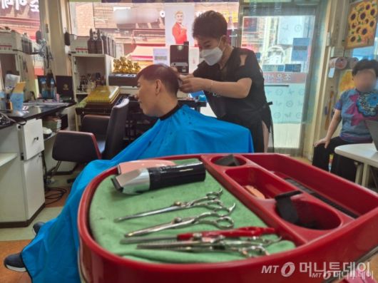 조씨는 30년 동안 사용한 가위를 꺼내들더니 숙달된 가위질로 머리카락을 잘라내며 "머리가 튀쳐나오면 인물이 덜 산다. 내가 잘 깎아내겠다"고 말했다. /사진=박진호 기자