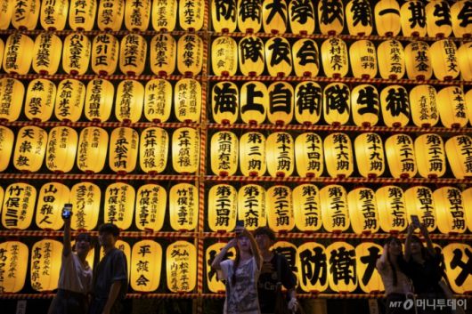 [도쿄=AP/뉴시스] 16일 일본 도쿄 야스쿠니 신사에서 미타마 마쓰리가 열려 방문객들이 노란색 등불 아래 사진을 찍고 있다. 1947년 전몰자 추모를 위해 시작된 미타마 마쓰리는 야스쿠니 신사에서 해마다 열리는 여름 축제로 3만 개 이상의 등불이 경내를 장식해 조상을 기리고 소원을 비는 방문객들을 맞는다. 2025.07.17.