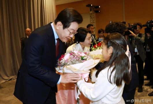 [워싱턴=뉴시스] 고범준 기자 = 이재명 대통령과 김혜경 여사가 24일(현지 시간) 미국 워싱턴DC의 한 호텔에서 열린 재미동포 만찬 간담회에서 화동에게 꽃다발을 받고 있다. 2025.08.25. bjko@newsis.com /사진=