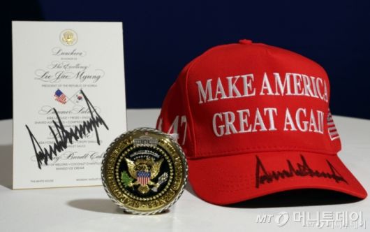 [워싱턴=뉴시스] 고범준 기자 = 대통령실이 25일(현지 시간) 공개한 도널드 트럼프 미국 대통령이 정상회담 후 이재명 대통령에게 준 선물. 백악관 기념 메달과 트럼프 대통령이 사인을 한 '마가'(MAGA·Make America Great Again·미국을 다시 위대하게) 모자와 오찬 메뉴판. 2025.08.26. bjko@newsis.com /사진=