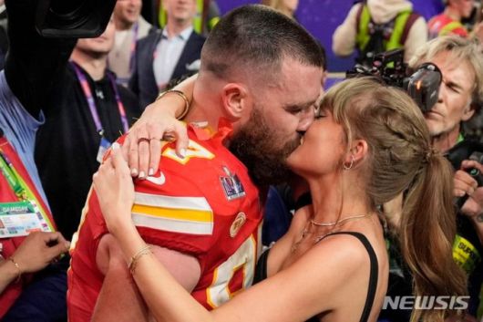 [라스베이거스=AP/뉴시스]지난해 12일(한국시간) 미국 네바다주 라스베이거스의 얼리전트 스타디움에서 열린 제58회 슈퍼볼에서 25:22로 샌프란시스코 포티나이너스를 꺾고 우승을 차지한 치프스 트래비스 켈시가 연인 테일러 스위프트와 입맞춤 하고 있다. 2025.08.27.