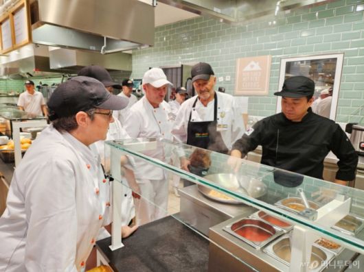 [서울=뉴시스] 더본코리아가 독일의 대형 유통그룹 글로버스 본사가 위치한 상트벤델 지역의 마크탈레 하이퍼마켓 푸드코트에서 더본코리아의 ‘글로벌 푸드 컨설팅 프랜차이즈’ 방식을 도입한 ‘비빔밥 및 덮밥’ 메뉴를 정식 론칭했다고 10일 밝혔다. 사진은 독일 글로버스 현지 조리사들에게 더본코리아가 컨설팅하는 모습. (사진=더본코리아 제공) 2025.07.10. photo@newsis.com *재판매 및 DB 금지 /사진=