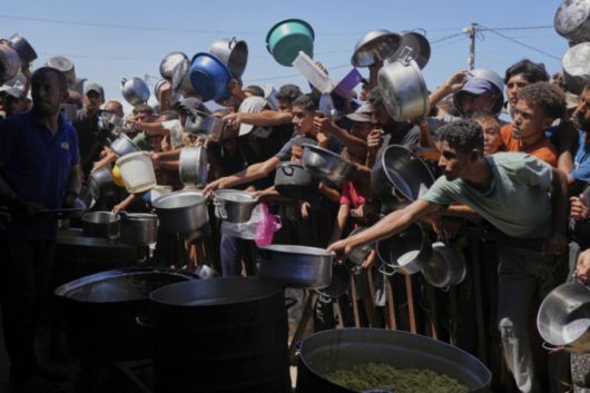 지난 1일(현지 시간) 가자지구 남부 칸유니스의 한 급식소에서 구호 음식을 받으려는 팔레스타인 주민들이 앞다퉈 모여들고 있다. /AP=뉴시스