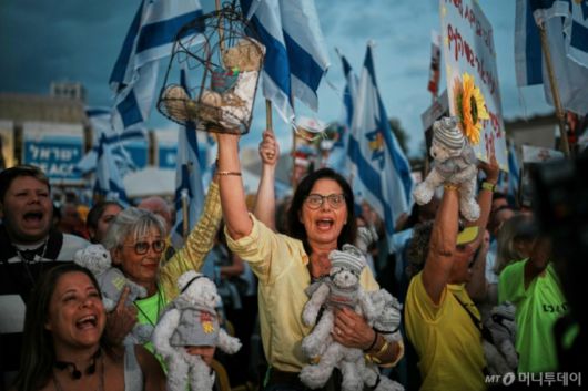 [텔아비브=AP/뉴시스] 13일(현지 시간) 이스라엘 텔아비브의 ‘인질 광장'에서 시민들이 가자지구에 억류된 이스라엘 인질들의 석방을 기다리고 있다. 이스라엘과 하마스의 '가자 평화 구상' 1단계 합의에 따라 이스라엘 인질 20명 전원(시신 28구 포함)과 팔레스타인 수감자 2000명의 교환이 이날 이루어진다. 2025.10.13. /사진=민경찬