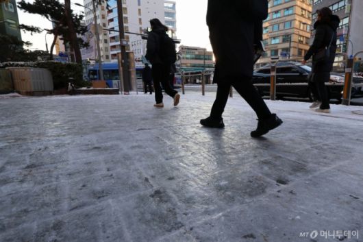 [서울=뉴시스] 권창회 기자 = 폭설 후 한파로 도로 곳곳이 얼어붙은 5일 오전 서울 중구 충무로역 인근에서 시민들이 빙판길을 조심히 걷고 있다. 2025.12.05. kch0523@newsis.com /사진=권창회