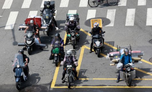 찜통 더위가 이어지고 있는 지난 7월23일 오후 서울 종로구의 한 도로에서 배달업 종사자들이 달궈진 아스팔트 위에서 신호를 기다리고 있다. /사진=뉴시스