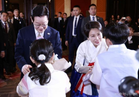 [베이징=뉴시스] 최동준 기자 = 중국을 국빈 방문 중인 이재명 대통령과 김혜경 여사가 4일(현지 시간) 베이징의 한 호텔에서 열린 재중 한국인 간담회에서 화동들에게 꽃다발을 받고 있다. 2026.01.04. photocdj@newsis.com /사진=최동준