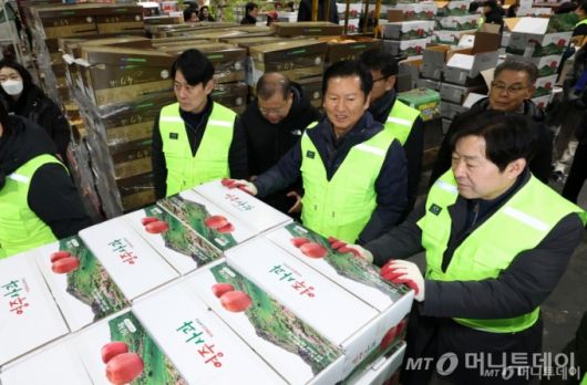 정청래(왼쪽 세 번째) 더불어민주당 대표가 7일 오전 서울 송파구 가락동 농수산물 종합도매시장 중앙청과에서 경매를 마친 사과 상자를 운반차에 싣고 있다. /사진=뉴시스