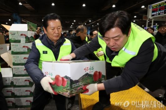 정청래(왼쪽) 더불어민주당 대표가 7일 오전 서울 송파구 가락동 농수산물 종합도매시장 중앙청과에서 경매를 마친 사과 상자를 운반차에 싣고 있다. /사진=뉴시스